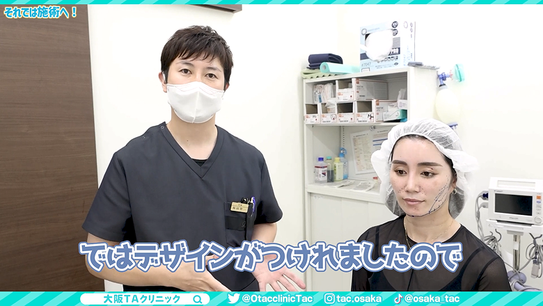 顔にデザインの線を描き終えた患者様と施術に移る福田医師